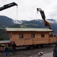 Holzhaus wird von 2 Kränen abgeladen