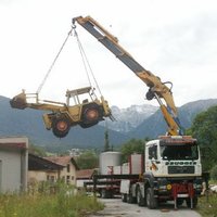 Lkw-Kran lädt einen Traktor ab